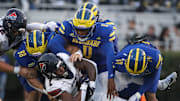 Delaware's Nick Karika (98) Q'yaeir Price (0) and K.T. Seay tackle Penn running back Malachi Hosley in the second quarter at Delaware Stadium, Saturday, Sept. 21, 2024.
