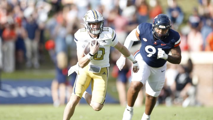 Nov 4, 2023; Charlottesville, Virginia, USA; Georgia Tech Yellow Jackets quarterback Haynes King (10) runs with the ball past Virginia Cavaliers defensive tackle Jason Hammond (91) during the first half at Scott Stadium. Mandatory Credit: Amber Searls-USA TODAY Sports