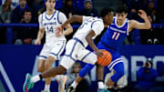 Air Force guard Ethan Taylor controls the ball under pressure from Boise State guard Alvaro Cardenas.