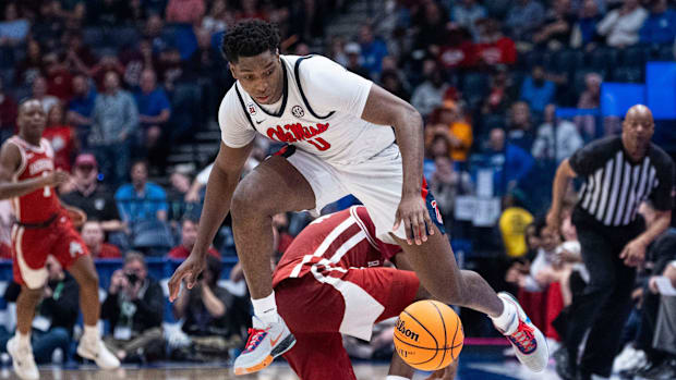 Ole Miss forward Malik Dia retrieves the ball after Razorbacks forward Billy Richmond III turned it over 