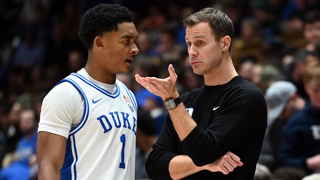 Jan 26, 2026; Durham, North Carolina, USA; Duke Blue Devils head coach Jon Scheyer (right) talks to guard Caleb Foster (1) during the second half against the Louisville Cardinals at Cameron Indoor Stadium. Mandatory Credit: Rob Kinnan-Imagn Images