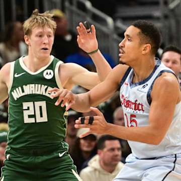 Dec 21, 2024; Milwaukee, Wisconsin, USA;  Washington Wizards guard Malcolm Brogdon (15) passes the ball against Milwaukee Bucks guard AJ Green (20) in the second quarter at Fiserv Forum. Mandatory Credit: Benny Sieu-Imagn Images