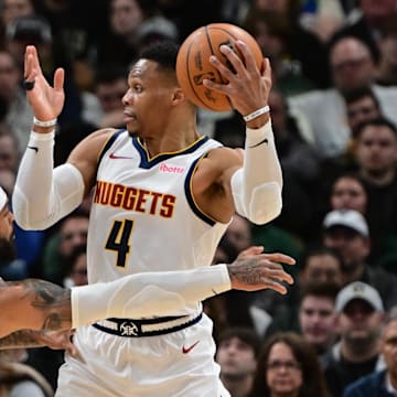 Feb 27, 2025; Milwaukee, Wisconsin, USA; Denver Nuggets guard Russell Westbrook (4) looks to pass the ball away from Milwaukee Bucks guard Gary Trent Jr. (5) in the second quarter at Fiserv Forum. Mandatory Credit: Benny Sieu-Imagn Images