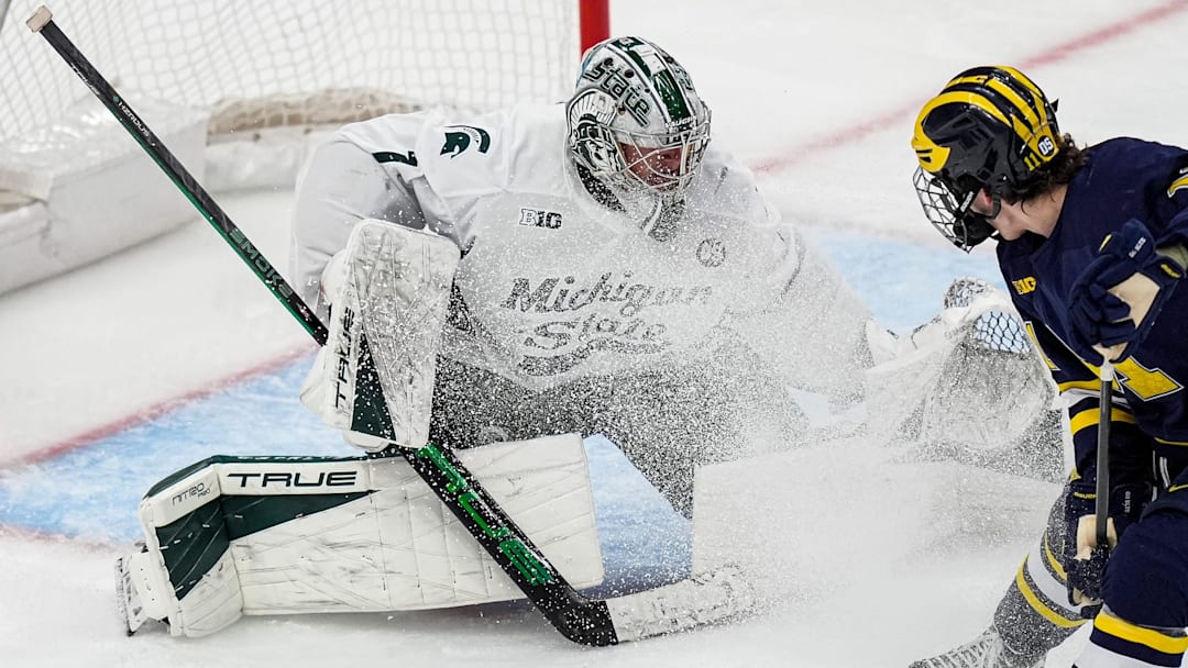 Michigan State goaltender Trey Augustine (1) makes a save against Michigan forward Cole McKinney (11) during the second period of Duel in the D at Little Caesars Arena in Detroit on Saturday, February 7, 2026. Michigan State goaltender Trey Augustine (1) makes a save against Michigan forward Cole McKinney (11) during the second period of Duel in the D at Little Caesars Arena in Detroit on Saturday, February 7, 2026.