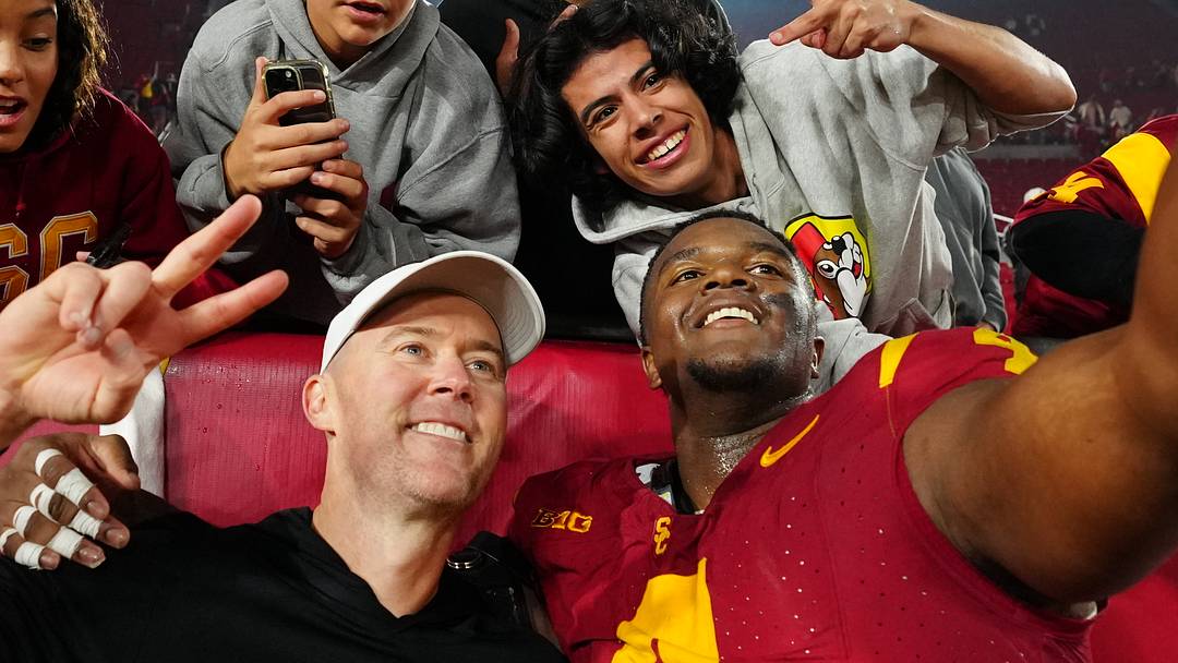 Nov 29, 2025; Los Angeles, California, USA; Southern California Trojans head coach Lincoln Riley (right) and defensive tackle Jahkeem Stewart (4) pose with fans after the game against the UCLA Bruins at United Airlines Field at Los Angeles Memorial Coliseum. 