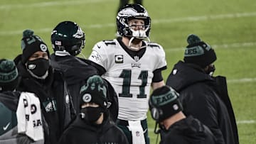 Dec 6, 2020; Green Bay, Wisconsin, USA; Philadelphia Eagles quarterback Carson Wentz (11) watches the game from the sidelines in the third quarter during the game against the Green Bay Packers at Lambeau Field.