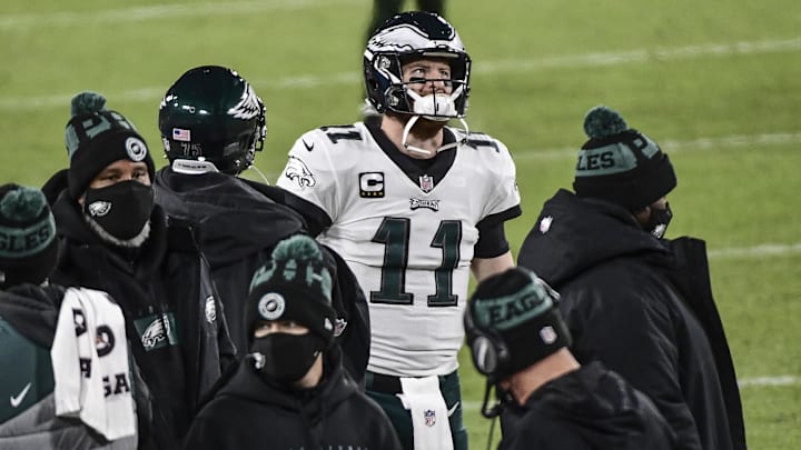 Dec 6, 2020; Green Bay, Wisconsin, USA; Philadelphia Eagles quarterback Carson Wentz (11) watches the game from the sidelines in the third quarter during the game against the Green Bay Packers at Lambeau Field.