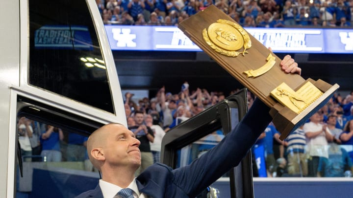 Mark Pope exits the bus with holding a trophy as he enters Rupp Arena greeting thousands of fans for his introductory press conference on Sunday, April 14, 2024.