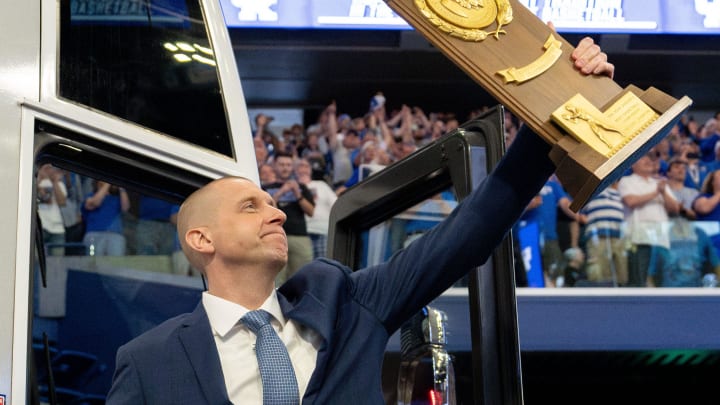 Mark Pope exits the bus with holding a trophy as he enters Rupp Arena greeting thousands of fans for his introductory press conference on Sunday, April 14, 2024.