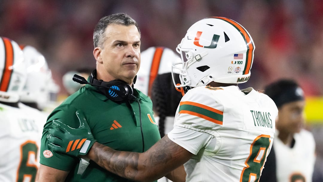 Jan 8, 2026; Glendale, AZ, USA; Miami Hurricanes head coach Mario Cristobal with defensive back Jakobe Thomas (8) against the Mississippi Rebels during the 2026 Fiesta Bowl and semifinal game of the College Football Playoff at State Farm Stadium. Mandatory Credit: Mark J. Rebilas-Imagn Images