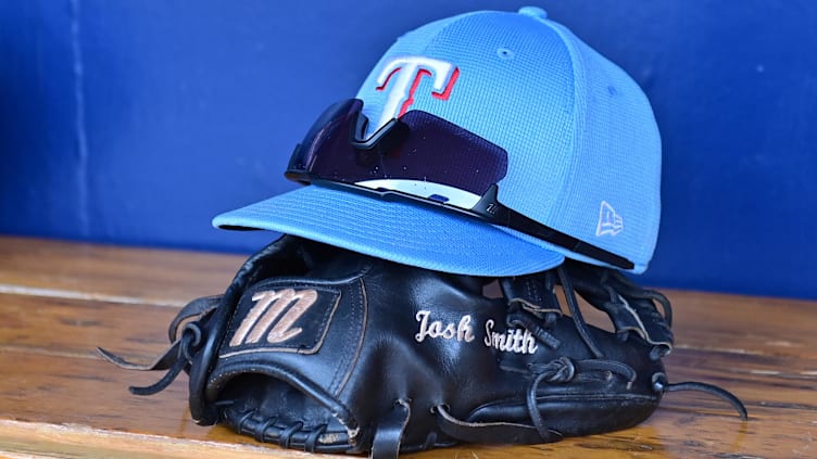 Mar 15, 2024; Salt River Pima-Maricopa, Arizona, USA; General view of a Texas Rangers hat, glove, and glasses prior to a spring training game against the Colorado Rockies at Salt River Fields at Talking Stick. Mandatory Credit: Matt Kartozian-USA TODAY Sports