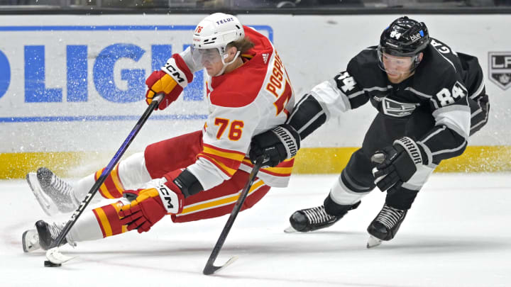 Apr 11, 2024; Los Angeles, California, USA;  Calgary Flames center Martin Pospisil (76) slides on the ice in front of Los Angeles Kings defenseman Vladislav Gavrikov (84) in the first period at Crypto.com Arena. Mandatory Credit: Jayne Kamin-Oncea-USA TODAY Sports