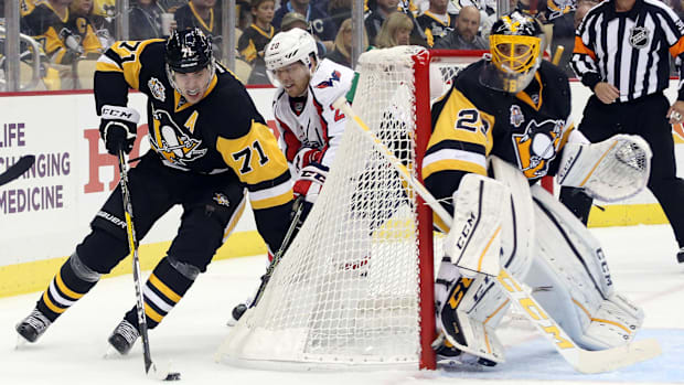 Hockey player circles behind net