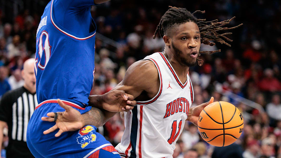 Mar 13, 2026; Kansas City, MO, USA; Houston Cougars forward Joseph Tugler (11) drives around Kansas Jayhawks forward Flory Bidunga (40) during the first half at T-Mobile Center. Mandatory Credit: William Purnell-Imagn Images