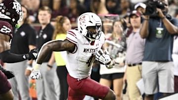Nov 16, 2024; College Station, Texas, USA; New Mexico State Aggies running back Mike Washington (4) runs the ball during the second half as Texas A&M Aggies linebacker Solomon DeShields (22) defends at Kyle Field. Mandatory Credit: Maria Lysaker-Imagn Images 