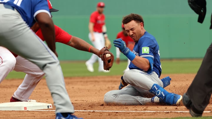 Mar 3, 2024; Fort Myers, Florida, USA; Boston Red Sox third baseman Rafael Devers (11) tags out Toronto Blue Jays outfielder Cam Eden (31) at third base during the fifth inning at JetBlue Park at Fenway South.