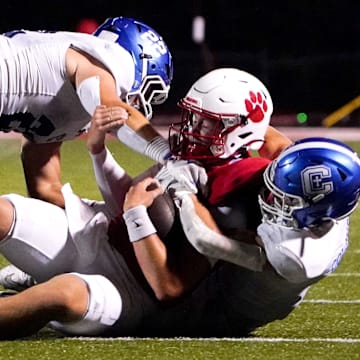 Covington Catholic Colonels Cash Myers (4) and Owen Pitzer (22) tackle Beechwood Tigers quarterback Emmett Queen in the second half of a high school football between the Covington Catholic Colonels and Beechwood Tigers, Friday, Sept. 19, 2025, at the Beechwood Tiger’s home field in Fort Mitchell, Ky. Colonels won 42-14.