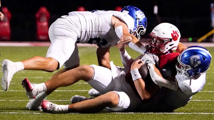 Covington Catholic Colonels Cash Myers (4) and Owen Pitzer (22) tackle Beechwood Tigers quarterback Emmett Queen in the second half of a high school football between the Covington Catholic Colonels and Beechwood Tigers, Friday, Sept. 19, 2025, at the Beechwood Tiger’s home field in Fort Mitchell, Ky. Colonels won 42-14.