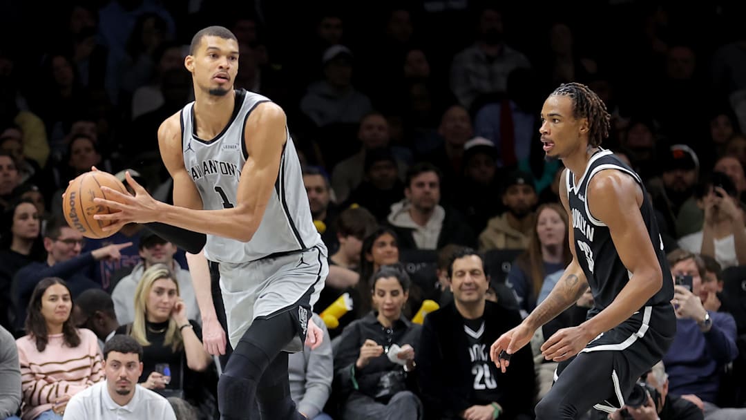 Feb 26, 2026; Brooklyn, New York, USA; San Antonio Spurs forward Victor Wembanyama (1) looks to pass the ball against Brooklyn Nets center Nic Claxton (33) during the third quarter at Barclays Center.