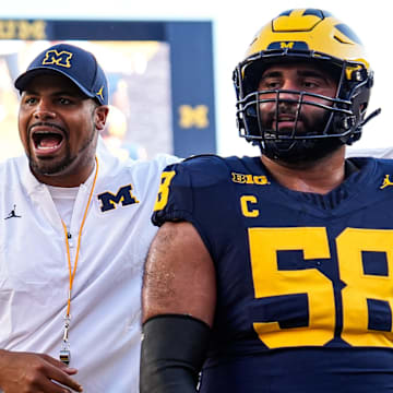 Michigan offensive line coach Grant Newsome, left, warm up next to offensive lineman Giovanni El-Hadi (58) ahead of the New Mexico game at Michigan Stadium in Ann Arbor on Saturday, August 30, 2025.