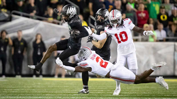 Oregon Ducks wide receiver Tez Johnson gets tripped up by Ohio State Buckeyes safety Caleb Downs as the No. 3 Oregon Ducks ho