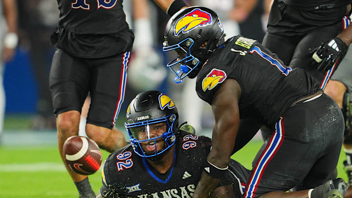Kansas Jayhawks players are unable to recover a fumble during the fourth quarter of a 23-20 loss to UNLV on Friday night. 