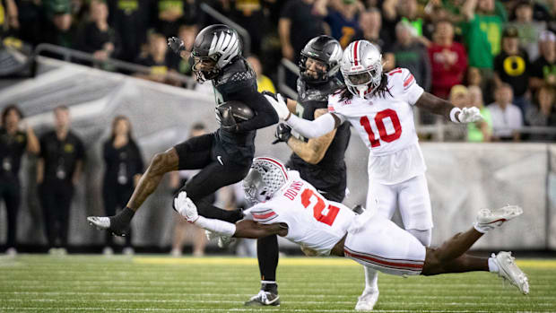Oregon Ducks wide receiver Tez Johnson gets tripped up by Ohio State Buckeyes safety Caleb Downs as the No. 3 Oregon Ducks ho