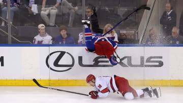 May 7, 2024; New York, New York, USA; New York Rangers defenseman Jacob Trouba (8) goes head first into the boards over Carolina Hurricanes center Martin Necas (88) during the first overtime of game two of the second round of the 2024 Stanley Cup Playoffs at Madison Square Garden. Mandatory Credit: Brad Penner-USA TODAY Sports