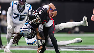 Jan 5, 2025; Atlanta, Georgia, USA; Carolina Panthers linebacker Jadeveon Clowney (7) tackles Atlanta Falcons quarterback Michael Penix Jr. (9) in the third quarter at Mercedes-Benz Stadium. Mandatory Credit: Brett Davis-Imagn Images