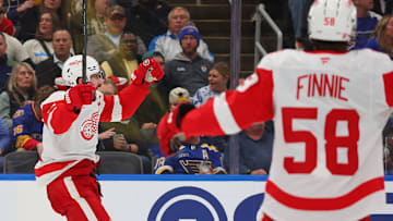 Emmitt Finnie (58) and Dylan Larkin celebrate as the Detroit Red Wings score against the St. Louis Blues.