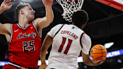 Dec 6, 2025; Raleigh, North Carolina, USA; NC State Wolfpack guard Quadir Copeland (11) goes for a dunk guarded by Liberty Flames forward Zach Cleveland (25) during the first half of the game at Lenovo Center. Mandatory Credit: Jaylynn Nash-Imagn Images