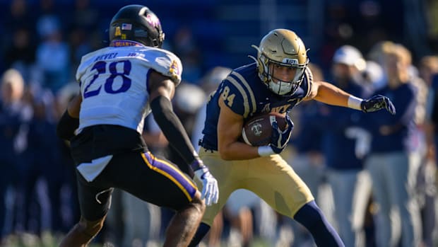 Navy Midshipmen wide receiver Regis Velez runs the ball against East Carolina Pirates defensive back Shavon Revel.