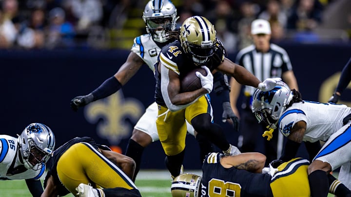 Dec 10, 2023; New Orleans, Louisiana, USA; New Orleans Saints running back Alvin Kamara (41) leaps over New Orleans Saints center Erik McCoy (78) on a run against Carolina Panthers safety Xavier Woods (25) during the first half at the Caesars Superdome. Mandatory Credit: Stephen Lew-Imagn Images