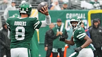 Sep 29, 2024; East Rutherford, New Jersey, USA;  New York Jets quarterback Aaron Rodgers (8) throws complete pass to wide receiver Garrett Wilson (5) against the Denver Broncos in the second half at MetLife Stadium.