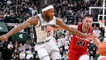Nov 19, 2024; East Lansing, Michigan, USA; Michigan State Spartans guard Tre Holloman (5) battles Samford Bulldogs guard Rylan Jones (21) for the ball during the first half at Jack Breslin Student Events Center. Mandatory Credit: Dale Young-Imagn Images