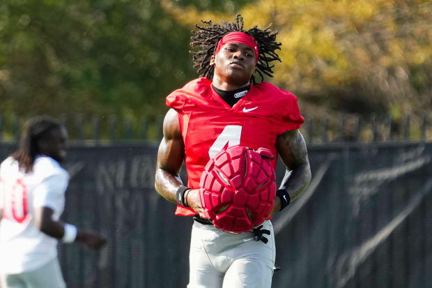 Wide receiver takes helmet off in practice.