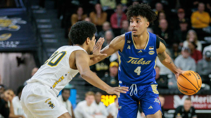 Feb 21, 2024; Wichita, Kansas, USA; Tulsa Golden Hurricane guard PJ Haggerty (4) brings the ball up court around Wichita State Shockers guard Harlond Beverly (20) during the second half at Charles Koch Arena. Mandatory Credit: William Purnell-USA TODAY Sports