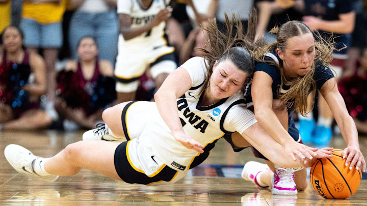 Iowa guard Taylor Stremlow (1) and FDU guard Reese Downey (25) dive for a loose ball March 21, 2026 during a First Round NCAA March Madness game at Carver-Hawkeye Arena in Iowa City, Iowa.