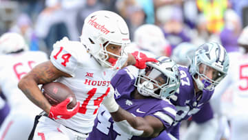 Oct 28, 2023; Manhattan, Kansas, USA; Houston Cougars wide receiver Jonah Wilson (14) stiff arms Kansas State Wildcats linebacker Tobi Osunsanmi (44) during the third quarter at Bill Snyder Family Football Stadium. Mandatory Credit: Scott Sewell-Imagn Images
