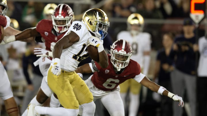 Nov 25, 2023; Stanford, California, USA; Notre Dame Fighting Irish running back Jeremiyah Love (12) eludes a tackle by Stanford Cardinal cornerback Collin Wright (6) during the second quarter at Stanford Stadium. Mandatory Credit: D. Ross Cameron-USA TODAY Sports