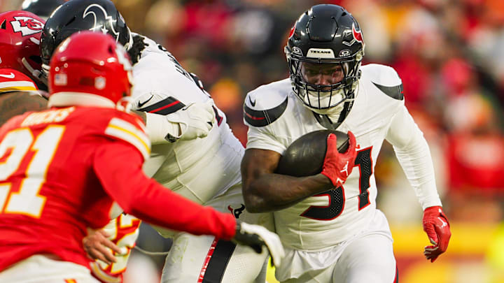 Jan 18, 2025; Kansas City, Missouri, USA; Former Houston Texans running back Dameon Pierce (31) runs the ball against Kansas City Chiefs safety Jaden Hicks (21) during the second half in a 2025 AFC divisional round game at GEHA Field at Arrowhead Stadium.