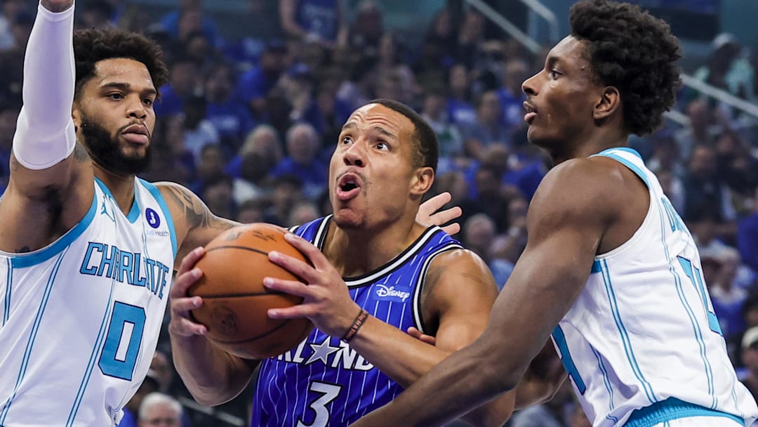 Apr 17, 2026; Orlando, Florida, USA; Orlando Magic guard Desmond Bane (3) goes to the basket against Charlotte Hornets forward Miles Bridges (0) and forward Moussa Diabate (14) during the first quarter during the play-in rounds of the 2026 NBA Playoffs at Kia Center. Mandatory Credit: Mike Watters-Imagn Images