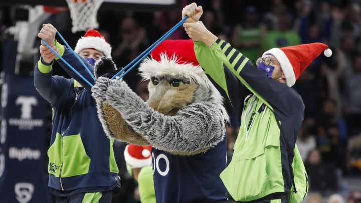 Dec 19, 2021; Minneapolis, Minnesota, USA; In the final home game before Christmas, Minnesota Timberwolves mascot Crunch dresses as Santa and his aides as elves as they deliver t-shirts to fans at the game with the Dallas Mavericks at Target Center. Mandatory Credit: Bruce Kluckhohn-USA TODAY Sports