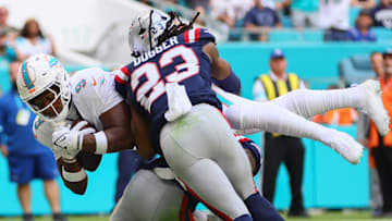 Nov 24, 2024; Miami Gardens, Florida, USA; Miami Dolphins tight end Jonnu Smith (9) dives into the end zone for a touchdown against New England Patriots safety Kyle Dugger (23) and cornerback Jonathan Jones (31) during the first quarter at Hard Rock Stadium. Mandatory Credit: Sam Navarro-Imagn Images