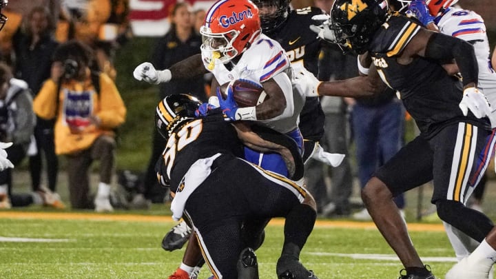 Nov 18, 2023; Columbia, Missouri, USA; Florida Gators running back Trevor Etienne (7) runs the ball as Missouri Tigers linebacker Chuck Hicks (30) makes the tackle during the first half at Faurot Field at Memorial Stadium. Mandatory Credit: Denny Medley-USA TODAY Sports