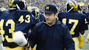 Michigan head coach Bo Schembechler on the field with his players at Michigan Stadium during the 1977 season.