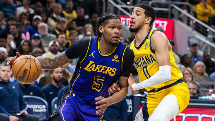 Mar 29, 2024; Indianapolis, Indiana, USA; Los Angeles Lakers forward Cam Reddish (5) dribbles  the ball while Indiana Pacers guard Tyrese Haliburton (0) defends in the second half at Gainbridge Fieldhouse. Mandatory Credit: Trevor Ruszkowski-USA TODAY Sports