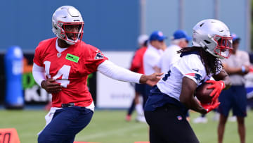 Jun 10, 2024; Foxborough, MA, USA;  New England Patriots quarterback Jacoby Brissett (14) hands the ball to running back Rhamondre Stevenson (38) at minicamp at Gillette Stadium. Mandatory Credit: Eric Canha-USA TODAY Sports