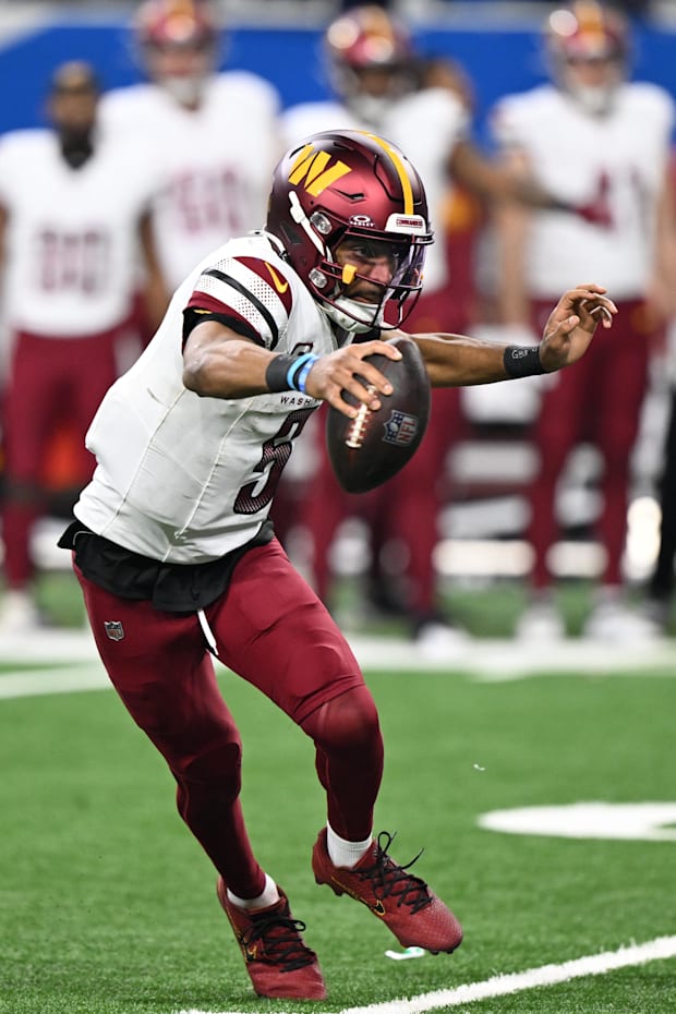 Washington Commanders quarterback Jayden Daniels (5) scrambles out of the pocket