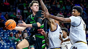 Nov 19, 2024; South Bend, Indiana, USA; North Dakota Fighting Hawks guard Treysen Eaglestaff (52) passes the ball as Notre Dame Fighting Irish forward Tae Davis (7) and forward Kebba Njie (14) defend in the second half at the Purcell Pavilion. Mandatory Credit: Matt Cashore-Imagn Images